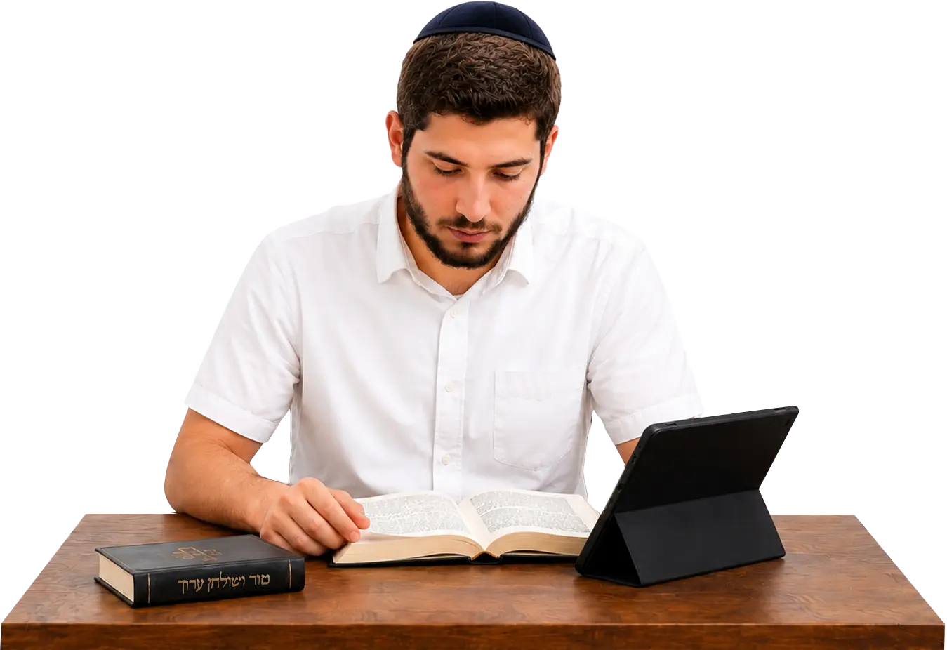 תלמיד לומד הלכה מתוך ספר שולחן ערוך לצד מחשב נייד